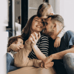 Famille souriante partageant un moment de tendresse à la maison, symbole de bonheur et de complicité.