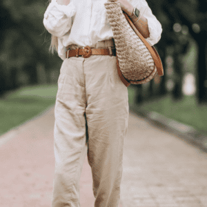 Femme portant un pantalon beige taille haute avec blouse blanche, tenue élégante et décontractée en extérieur