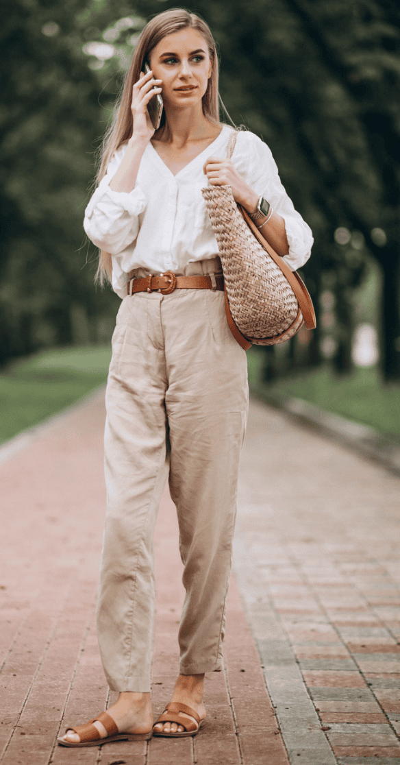 Pantalon beige femme – coupe élégante et confortable Femme portant un pantalon beige taille haute avec blouse blanche, tenue élégante et décontractée en extérieur