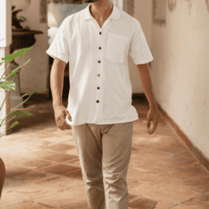 Homme portant un pantalon beige avec chemise blanche, style élégant et décontracté en intérieur