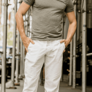 Homme portant un pantalon blanc coupe droite avec t-shirt, look décontracté et moderne en extérieur