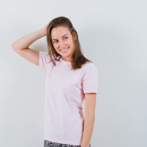 Femme portant un t-shirt rose clair, style casual confortable, tenue simple et moderne