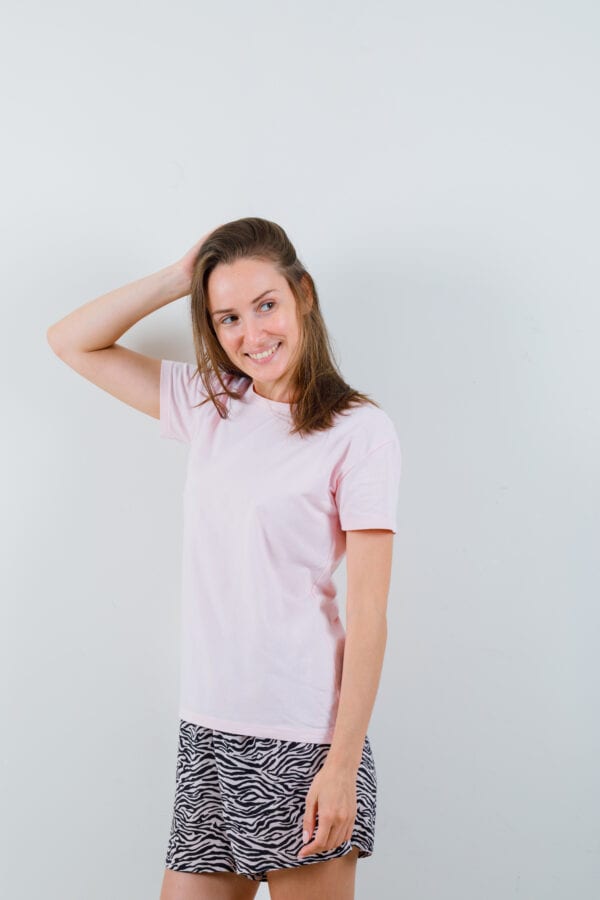 Femme portant un t-shirt rose clair, style casual confortable, tenue simple et moderne