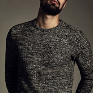 Homme portant un pull en laine française gris Etikashion, style moderne et élégant en studio